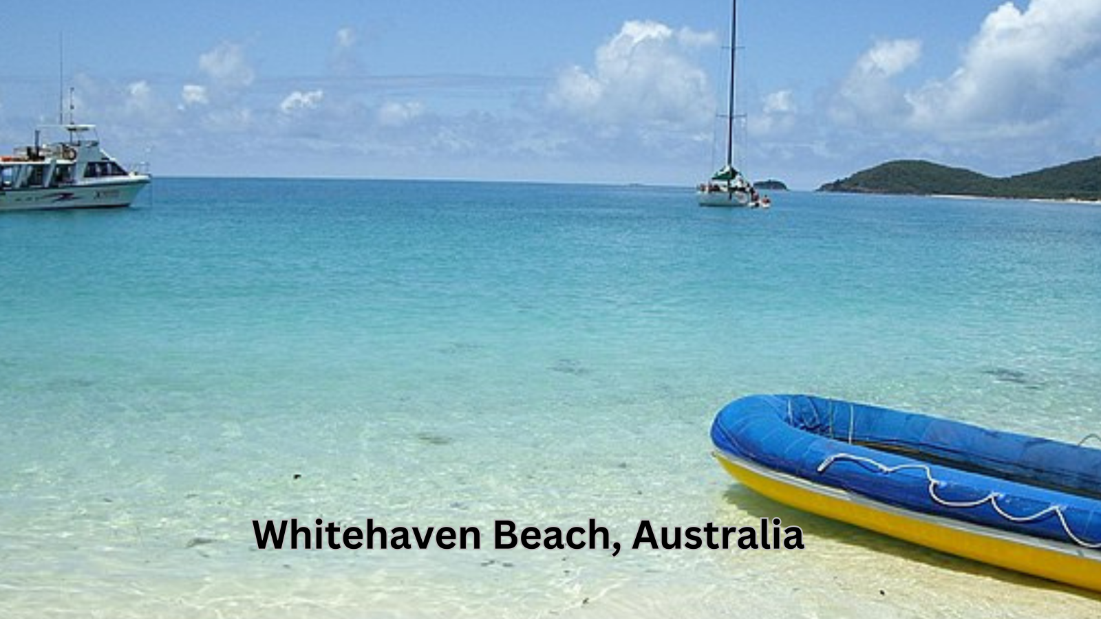 Panoramic view of Whitehaven Beach, Australia, showcasing its white silica sand and clear blue waters.